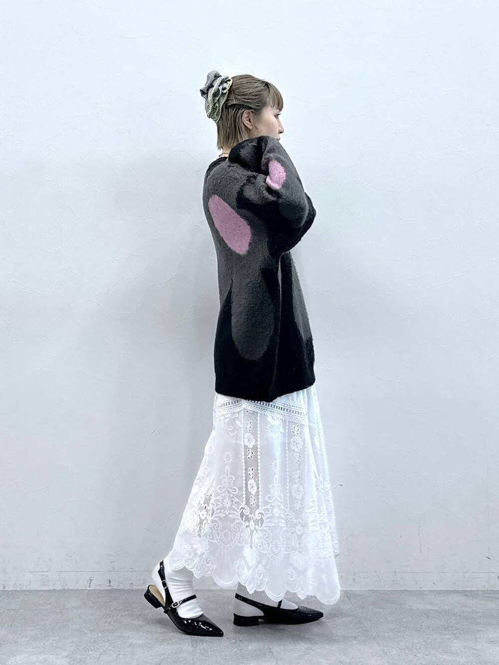 ブラック系のニット/セーター、ホワイト系のスカート、ブラック系のパンプスを着用したレディースの冬コーディネートの5枚目の写真