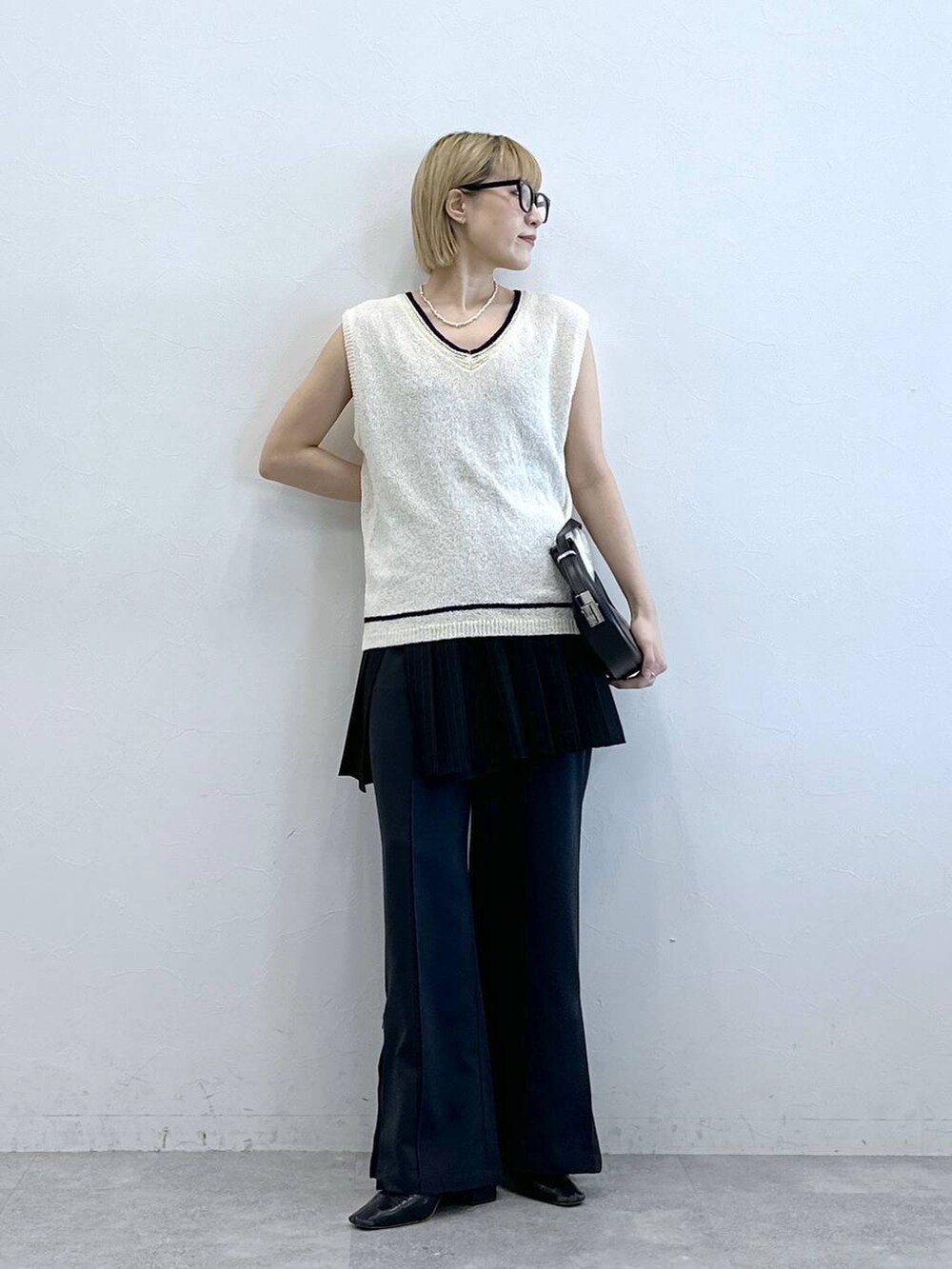 ホワイト系のニット/セーター、その他のスラックス、ブラック系のスカートを着用したレディースの夏コーディネートの5枚目の写真