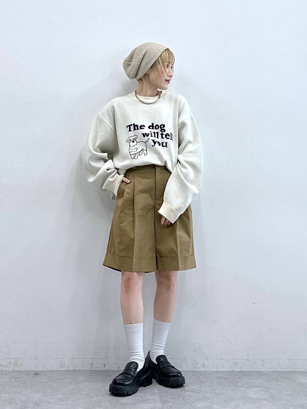 ホワイト系のニット/セーター、ブラック系のローファー、ブラウン系のチノパンツを着用したレディースの秋コーディネートの2枚目の写真