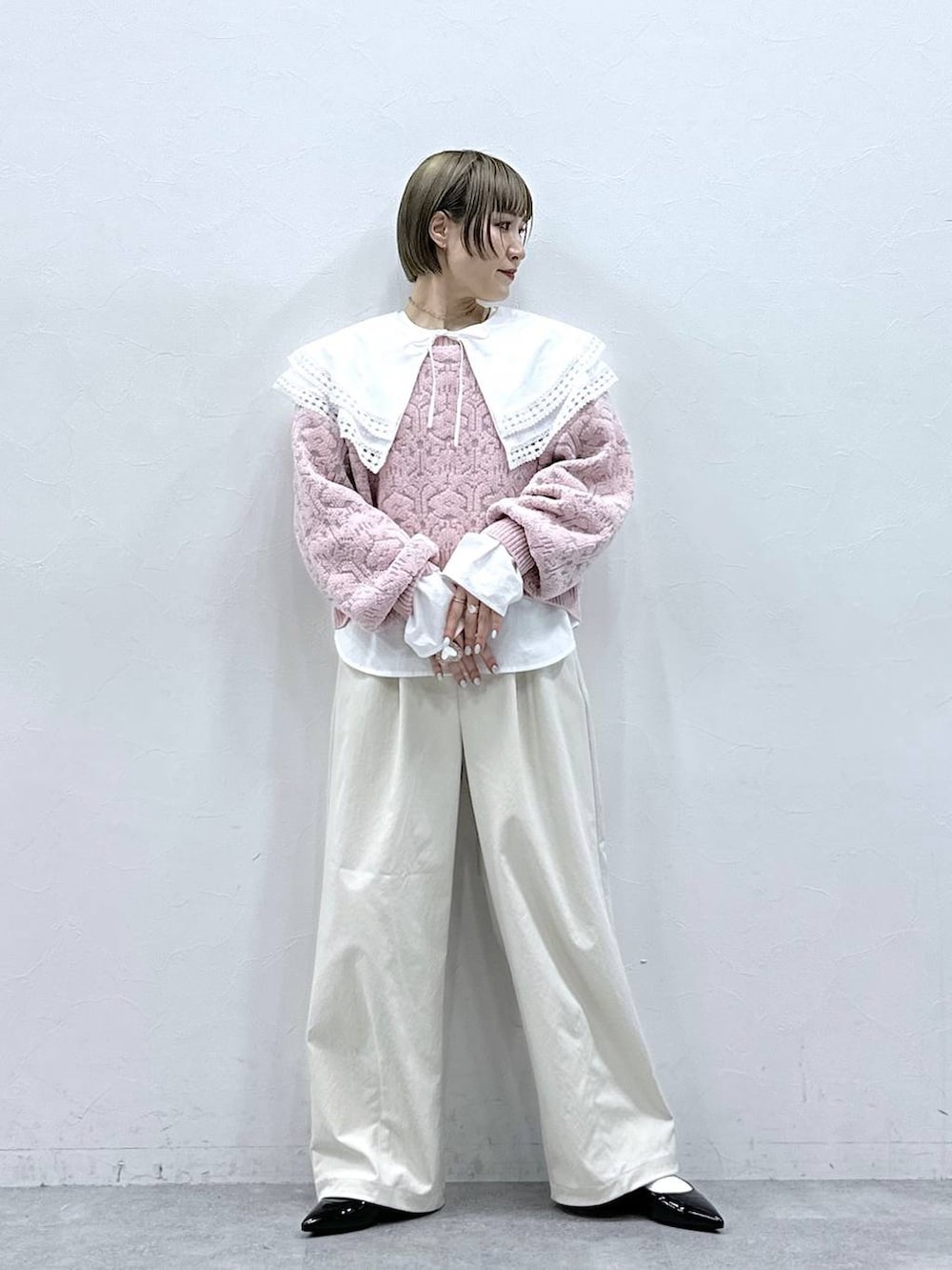 ホワイト系のチノパンツ、ホワイト系のシャツ/ブラウス、ピンク系のニット/セーターを着用したレディースの冬コーディネートの4枚目の写真