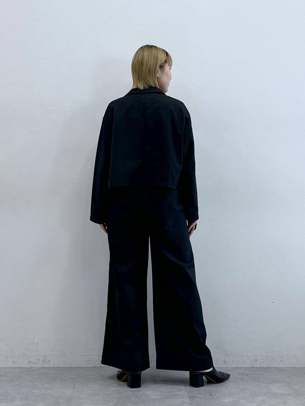 ブラック系のテーラードジャケット、ホワイト系のTシャツ/カットソーを着用したレディースの秋コーディネートの6枚目の写真