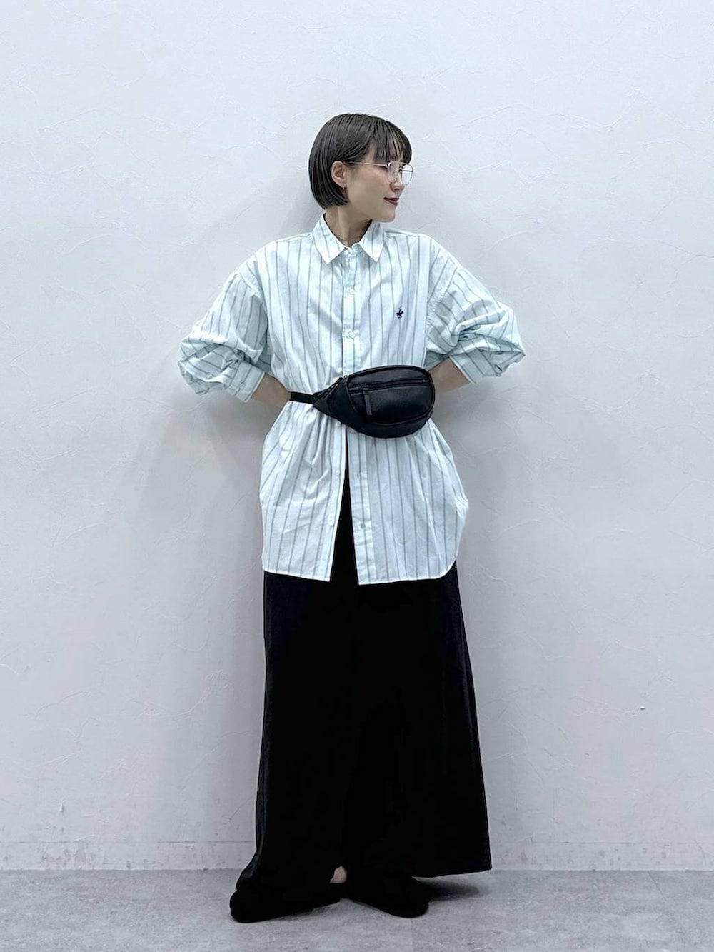 グリーン系のシャツ/ブラウス、ブラック系のボディバッグ/ウエストポーチ、ブラック系のモカシン/デッキシューズを着用したレディースの春コーディネートの2枚目の写真