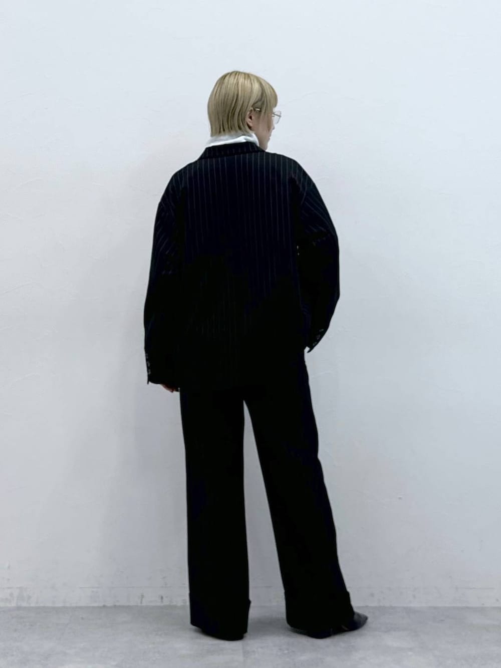 ホワイト系のスウェット、ブラック系のスラックス、ブラック系のテーラードジャケットを着用したレディースの秋コーディネートの5枚目の写真