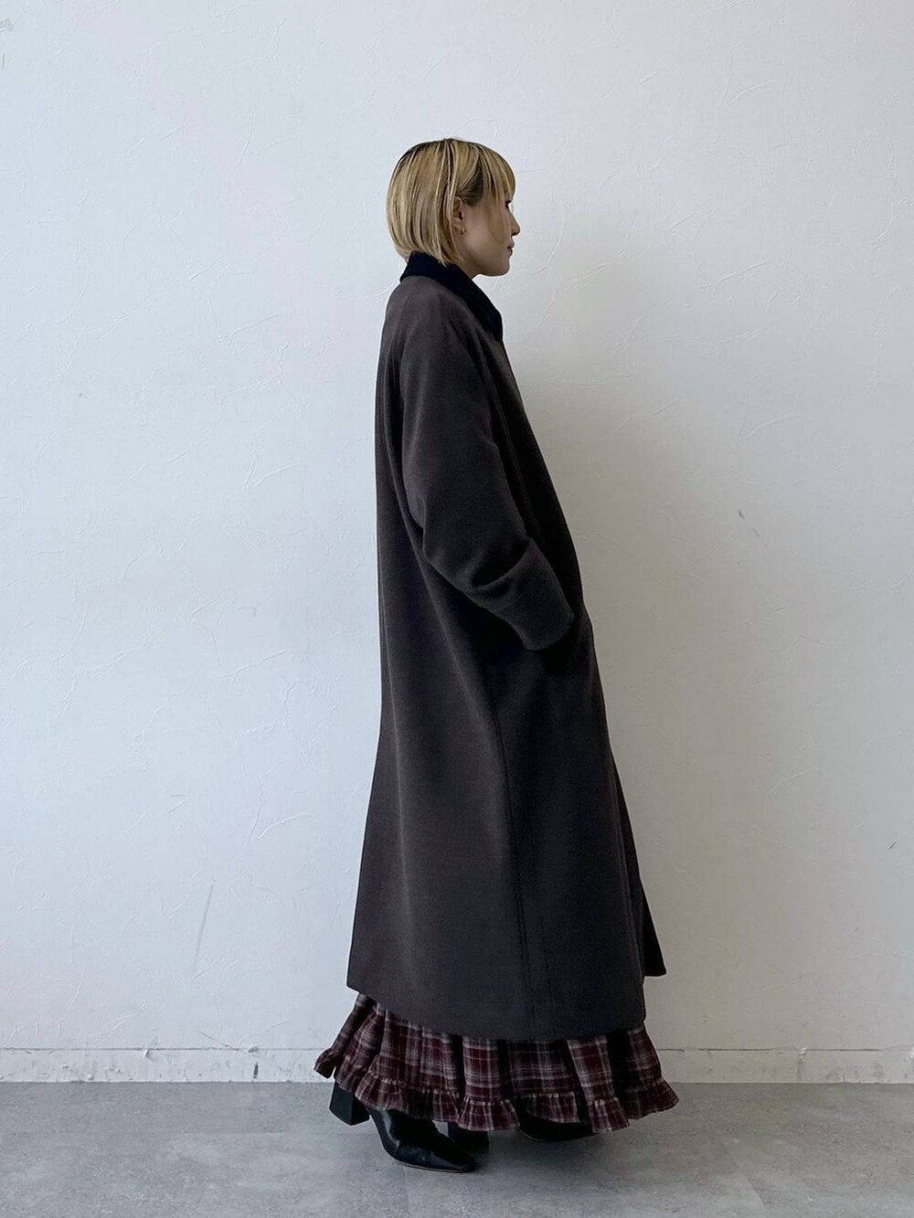 ブラウン系のステンカラーコート、レッド系のスカートを着用したレディースの秋コーディネートの4枚目の写真