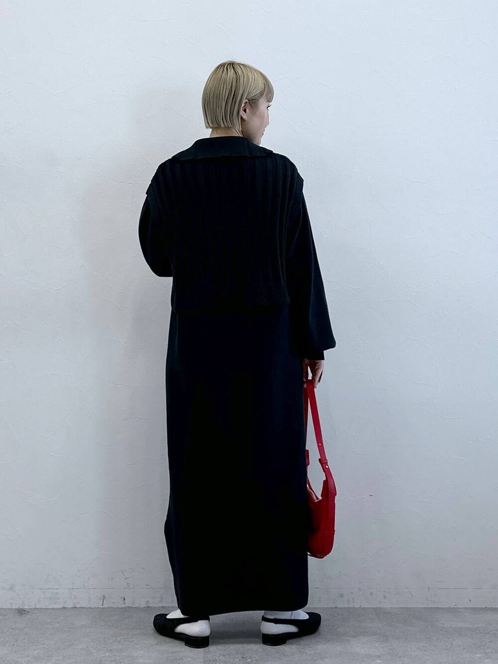 ブラック系のパンプス、レッド系のショルダーバッグ、ブラック系のワンピースを着用したレディースの冬コーディネートの4枚目の写真