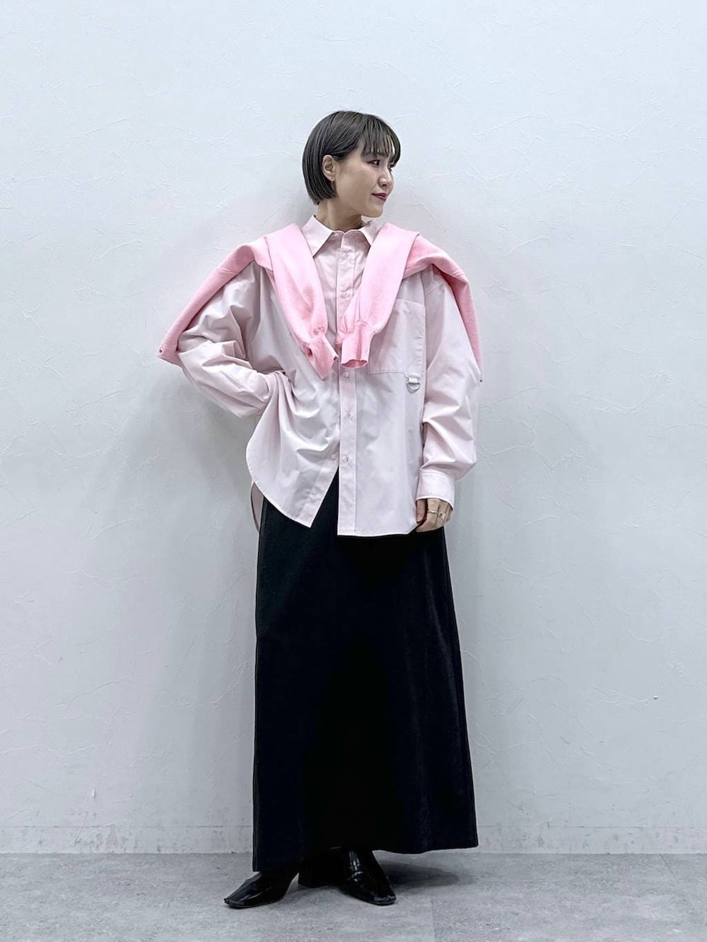 ピンク系のカーディガン/ボレロ、ブラック系のスカート、ピンク系のシャツ/ブラウスを着用したレディースの春コーディネートの3枚目の写真