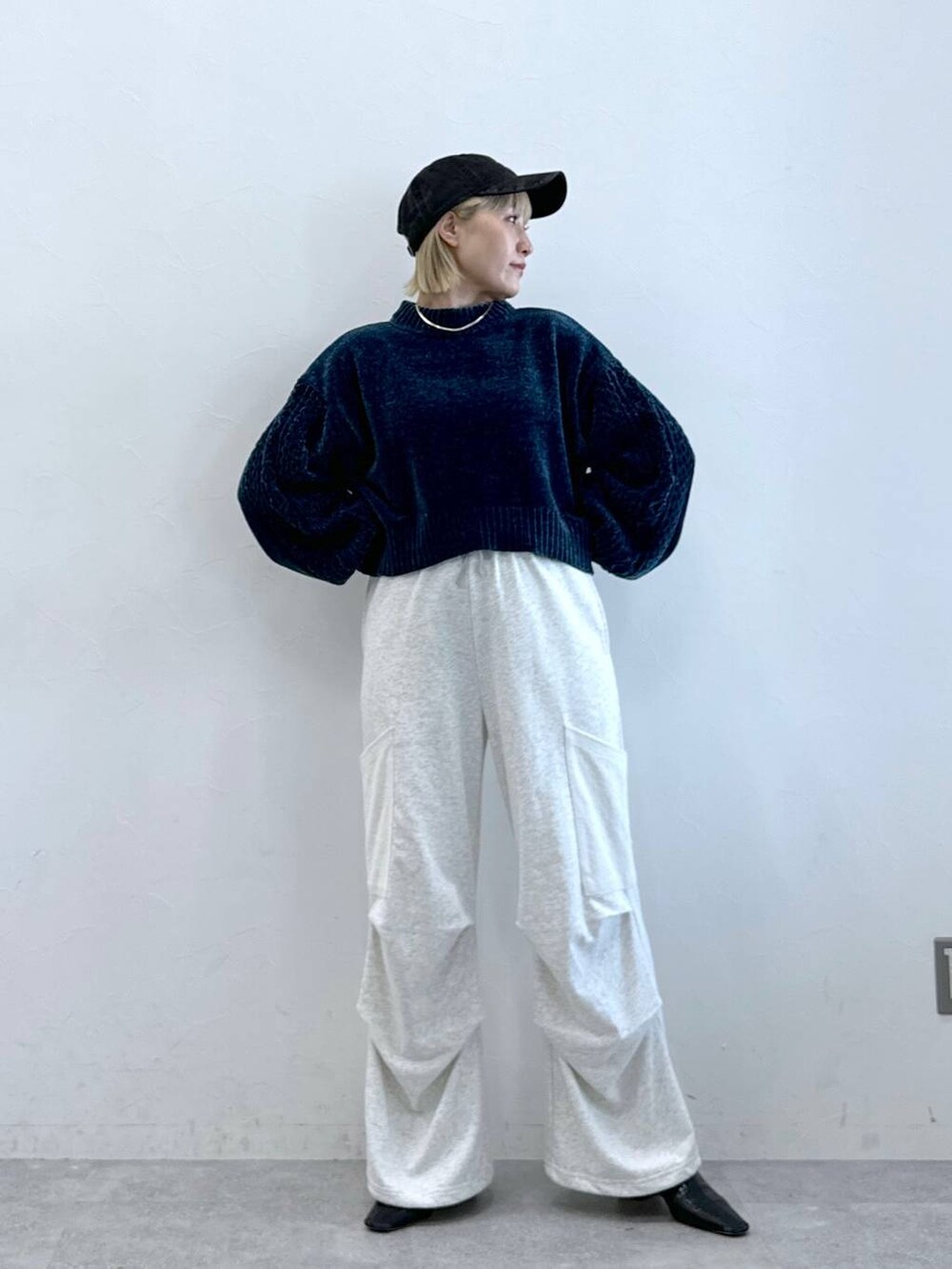 ホワイト系のカーゴパンツ、ブルー系のニット/セーター、ブラック系のキャップを着用したレディースの夏コーディネートの2枚目の写真