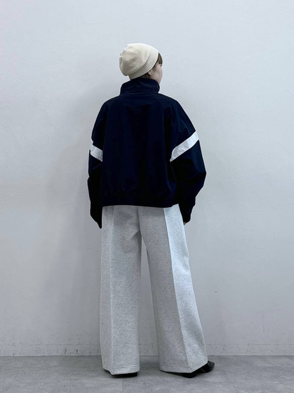 ホワイト系のスウェットパンツ、ブルー系のブルゾン、ホワイト系のTシャツ/カットソーを着用したレディースの冬コーディネートの7枚目の写真