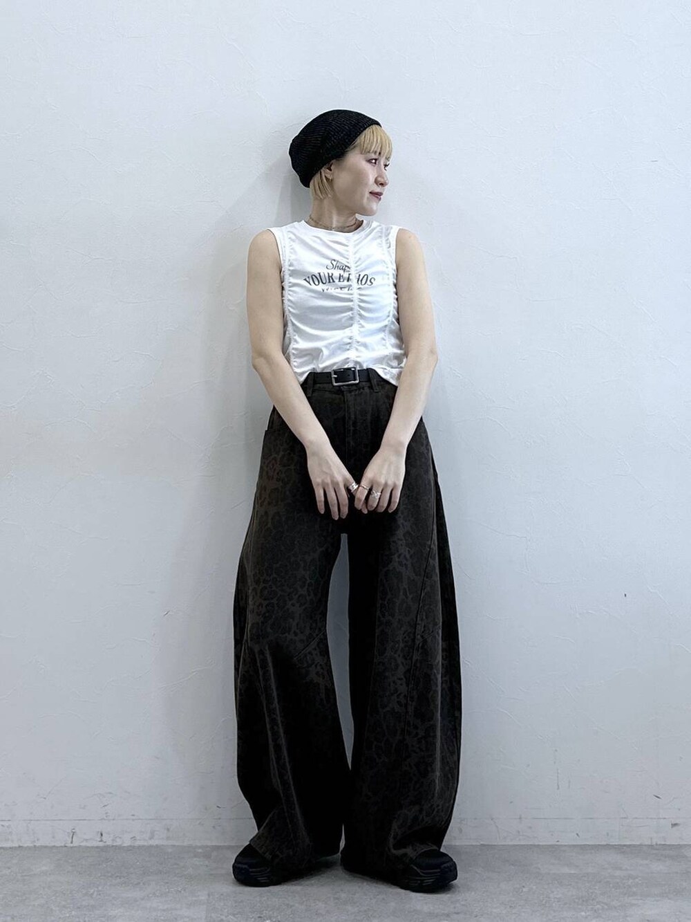 ブラック系のサンダル、ブラウン系のデニムパンツ、ホワイト系のTシャツ/カットソーを着用したレディースの春コーディネートの2枚目の写真