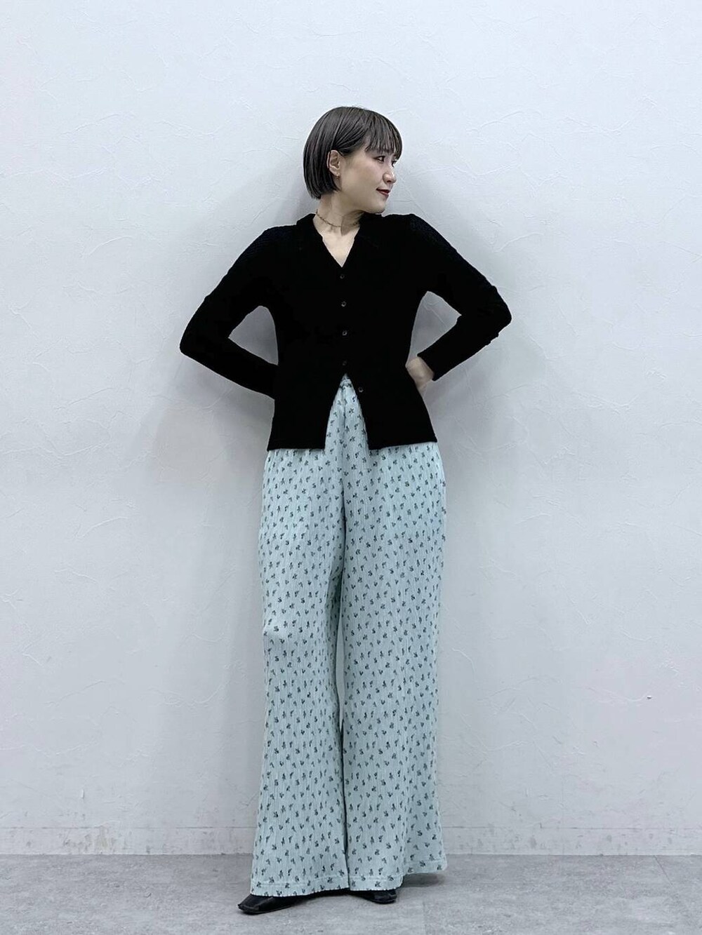 ブルー系のスラックス、ブラック系のカーディガン/ボレロを着用したレディースの春コーディネートの3枚目の写真