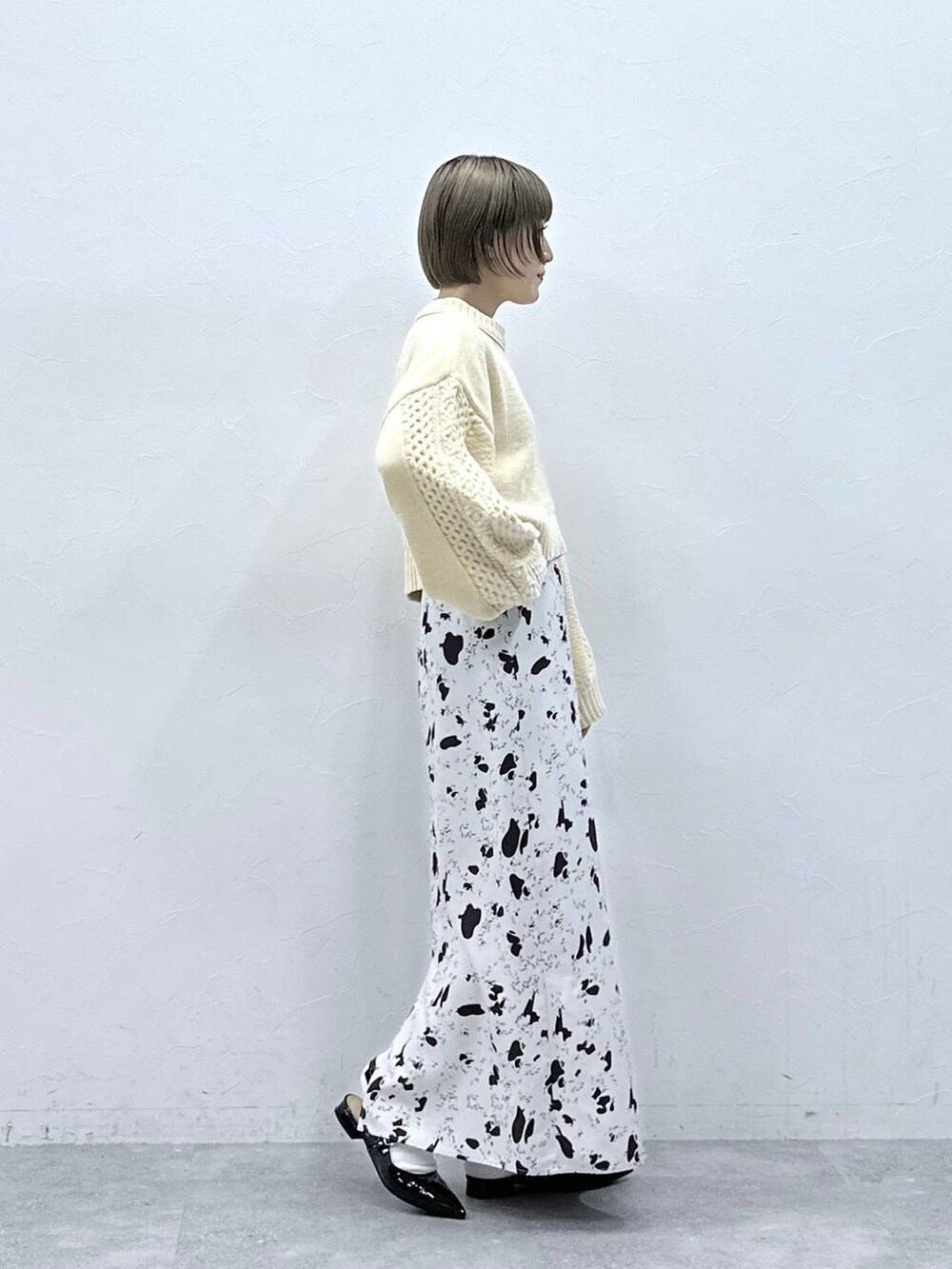 ホワイト系のニット/セーター、ブラウン系のスカート、ブラック系のパンプスを着用したレディースの冬コーディネートの4枚目の写真