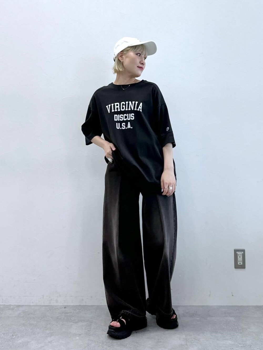 ブルー系のデニムパンツ、ブラック系のサンダル、ホワイト系のTシャツ/カットソーを着用したレディースの夏コーディネートの3枚目の写真