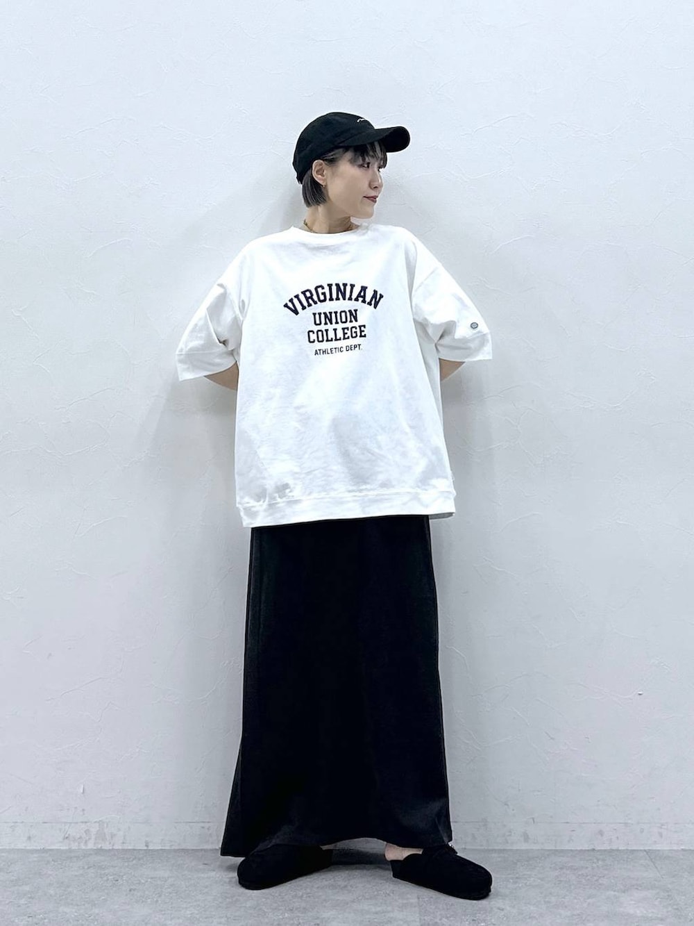 ホワイト系のTシャツ/カットソー、ブラック系のモカシン/デッキシューズ、ブラック系のスカートを着用したレディースの春コーディネートの3枚目の写真