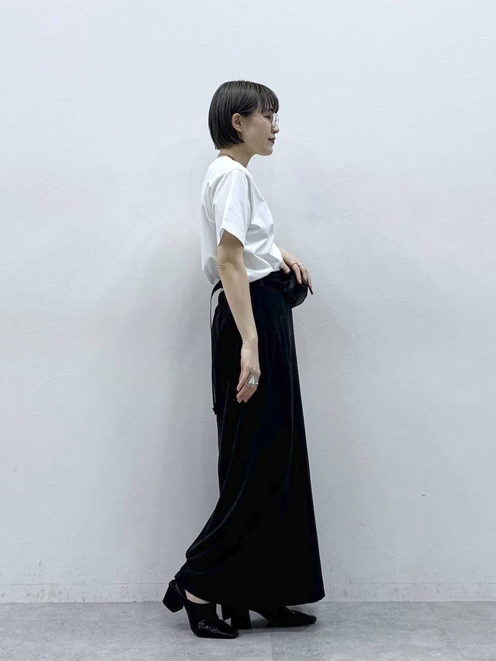 ブラック系のボディバッグ/ウエストポーチ、ブラック系のスカート、ホワイト系のTシャツ/カットソーを着用したレディースの春コーディネートの6枚目の写真