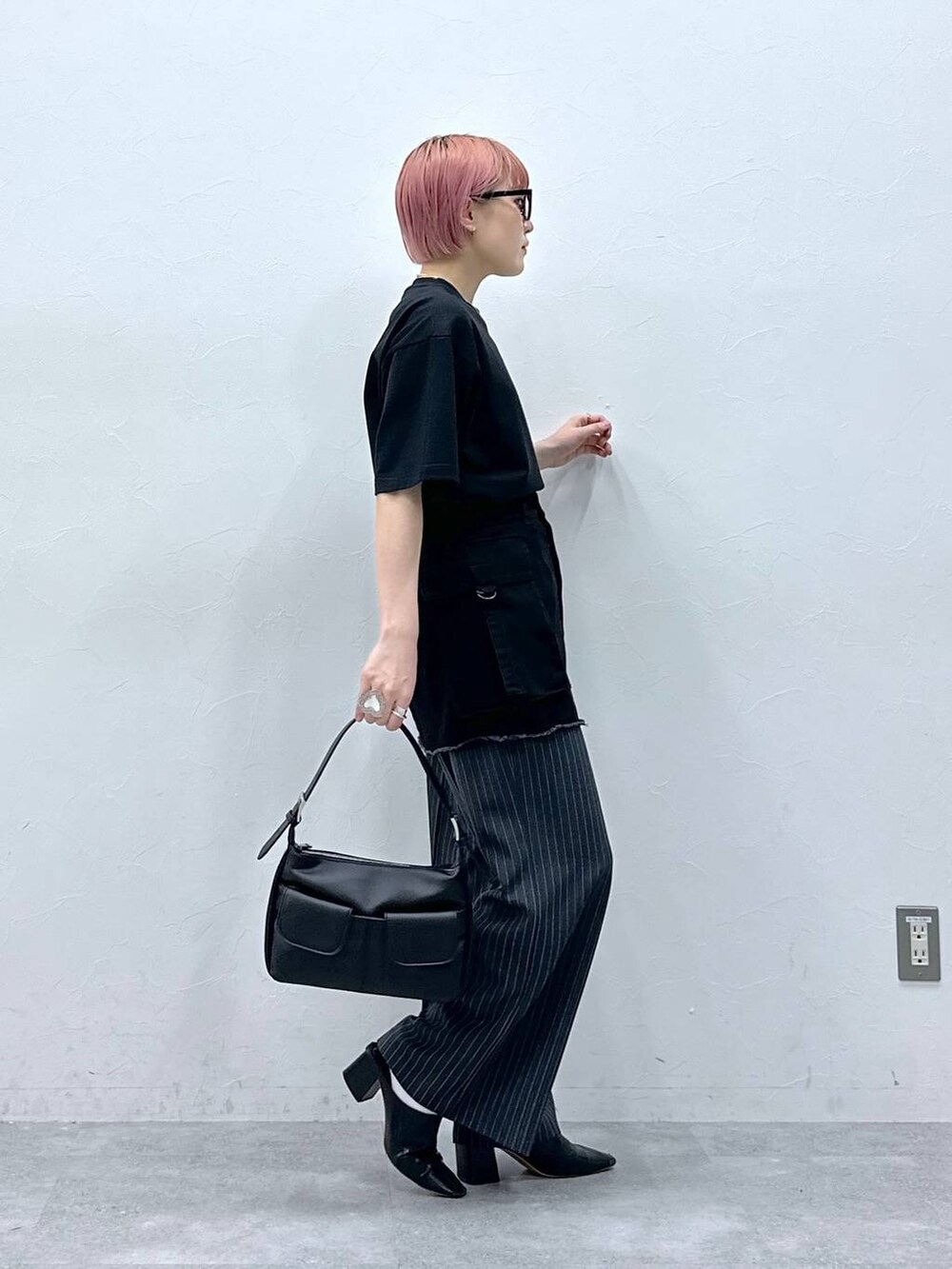 グレー系のスラックス、ブラック系のTシャツ/カットソー、ブラック系のスカートを着用したレディースの春コーディネートの4枚目の写真