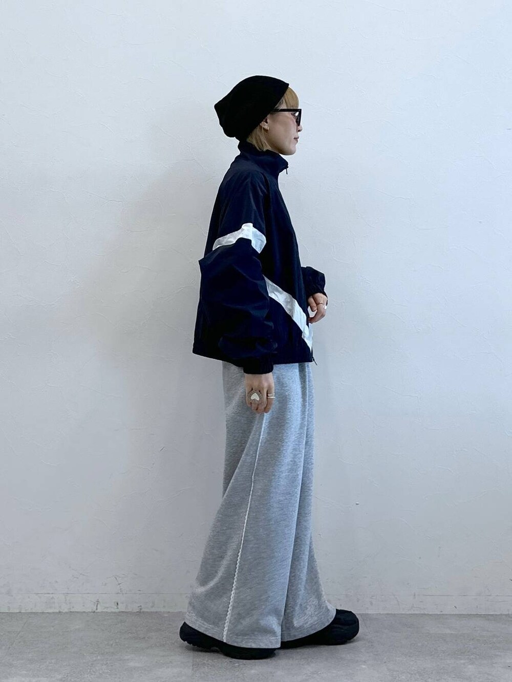 グレー系のスウェットパンツ、ブルー系のブルゾン、ブラック系のニットキャップ/ビーニーを着用したレディースの夏コーディネートの4枚目の写真