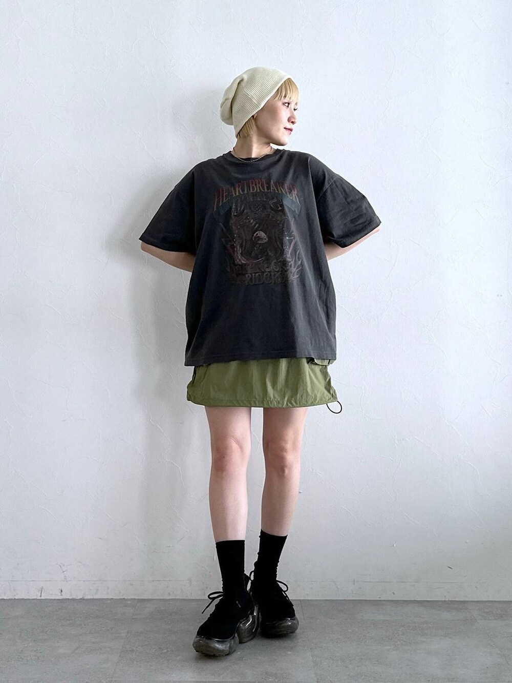グリーン系のスカート、ブラック系のTシャツ/カットソーを着用したレディースの夏コーディネートの2枚目の写真