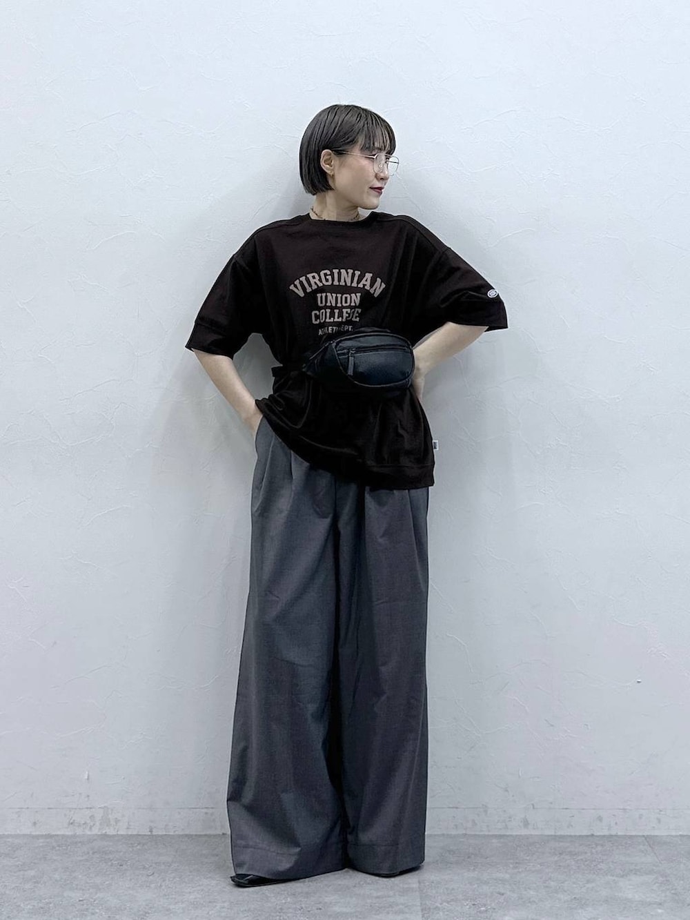 ブラウン系のTシャツ/カットソー、ブラック系のボディバッグ/ウエストポーチ、グレー系のスラックスを着用したレディースの春コーディネートの3枚目の写真