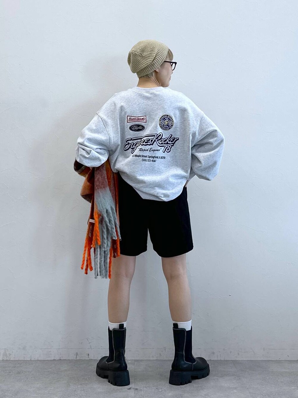 ブラック系のチノパンツ、ブラック系のブーツ、グレー系のスウェットを着用したレディースの冬コーディネートの4枚目の写真