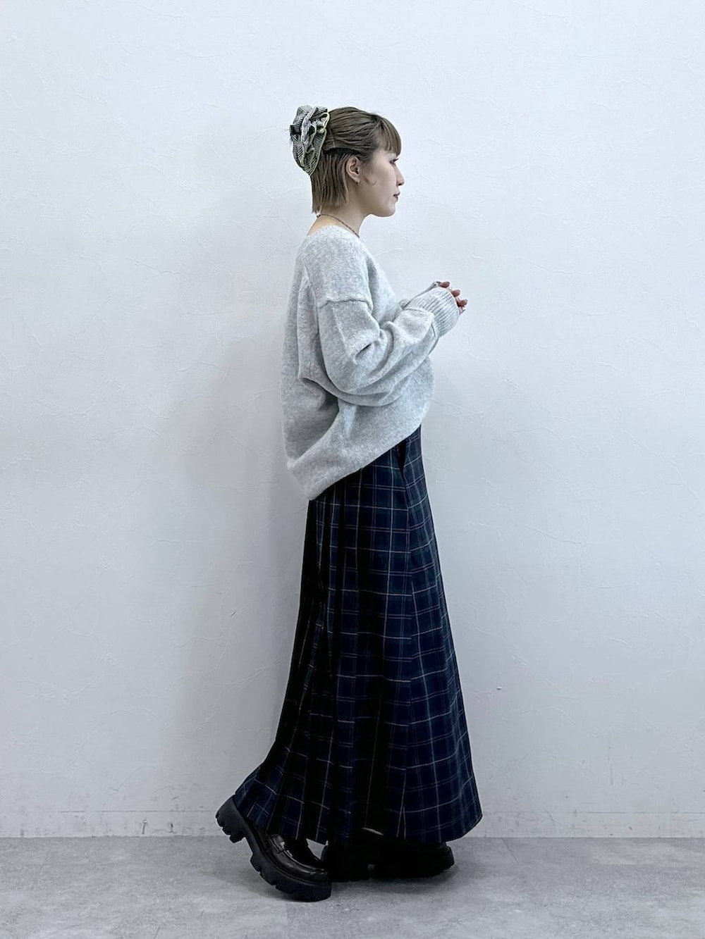 ブラック系のローファー、グリーン系のスカート、グレー系のニット/セーターを着用したレディースの冬コーディネートの4枚目の写真