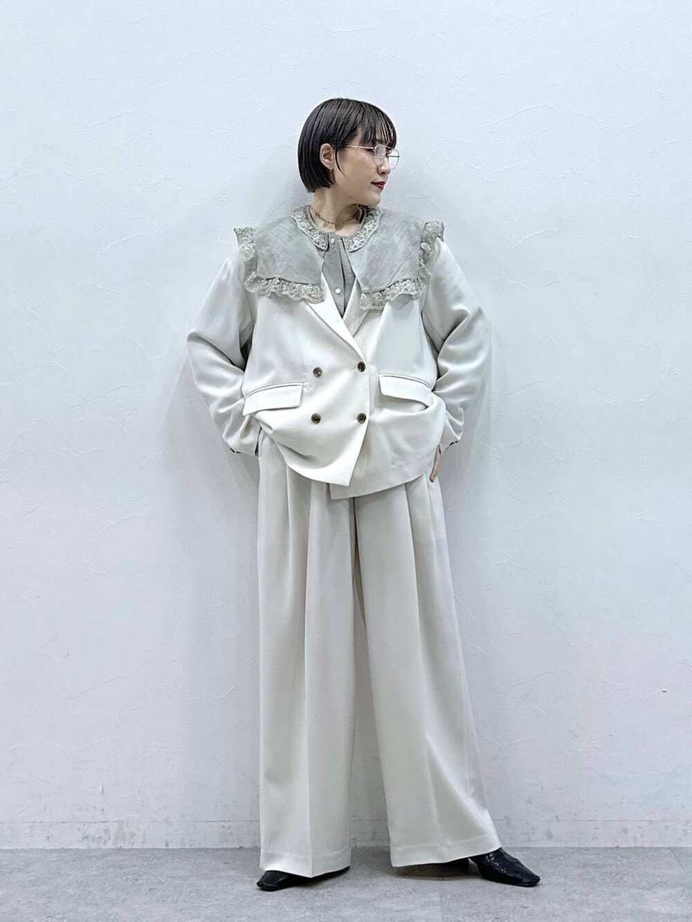 グリーン系のシャツ/ブラウス、ホワイト系のテーラードジャケット、ホワイト系のスラックスを着用したレディースの春コーディネートの4枚目の写真