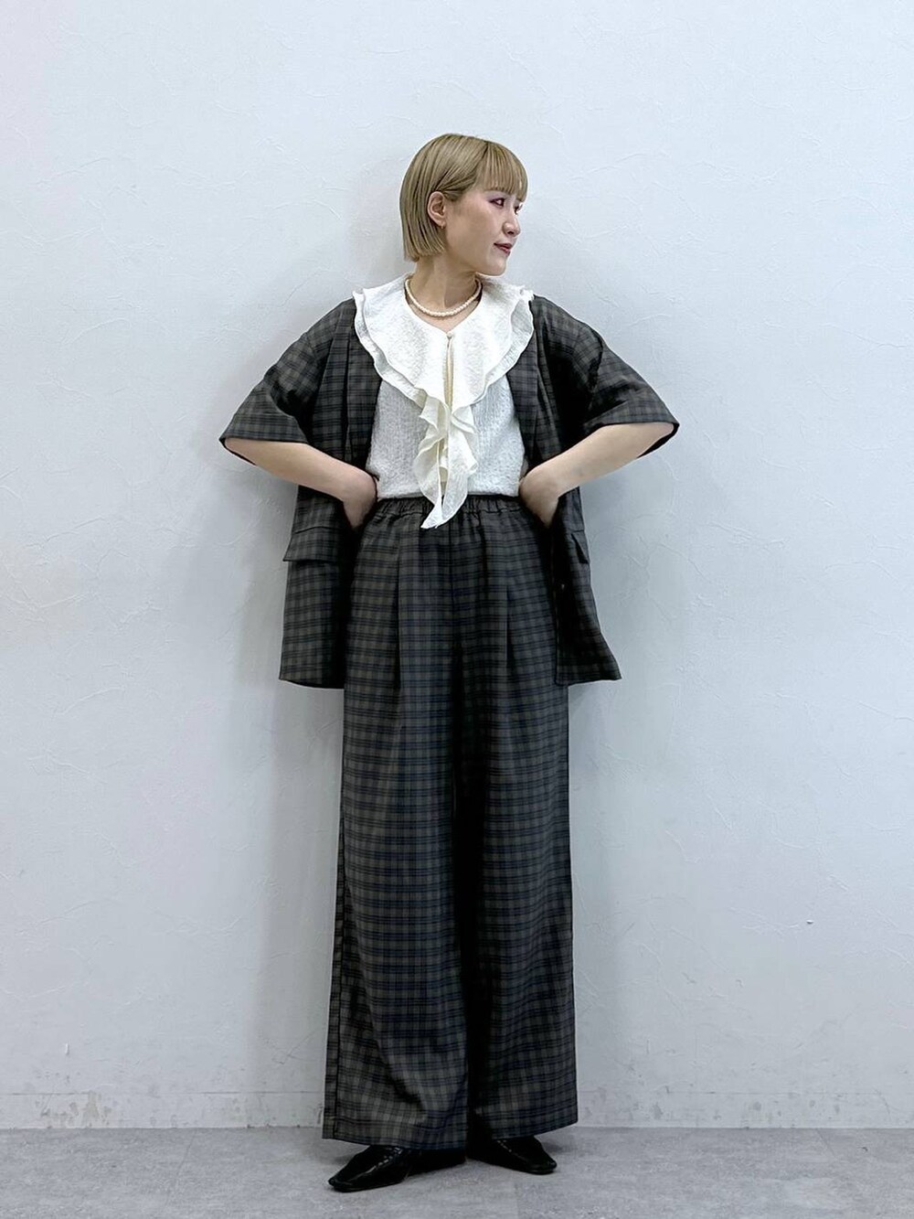 ホワイト系のシャツ/ブラウス、イエロー系のテーラードジャケット、イエロー系のスラックスを着用したレディースの夏コーディネートの3枚目の写真