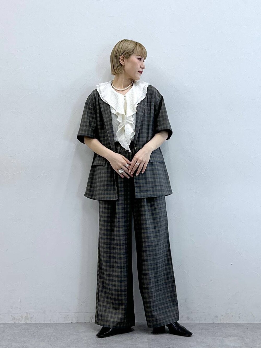 ホワイト系のシャツ/ブラウス、イエロー系のテーラードジャケット、イエロー系のスラックスを着用したレディースの夏コーディネートの4枚目の写真