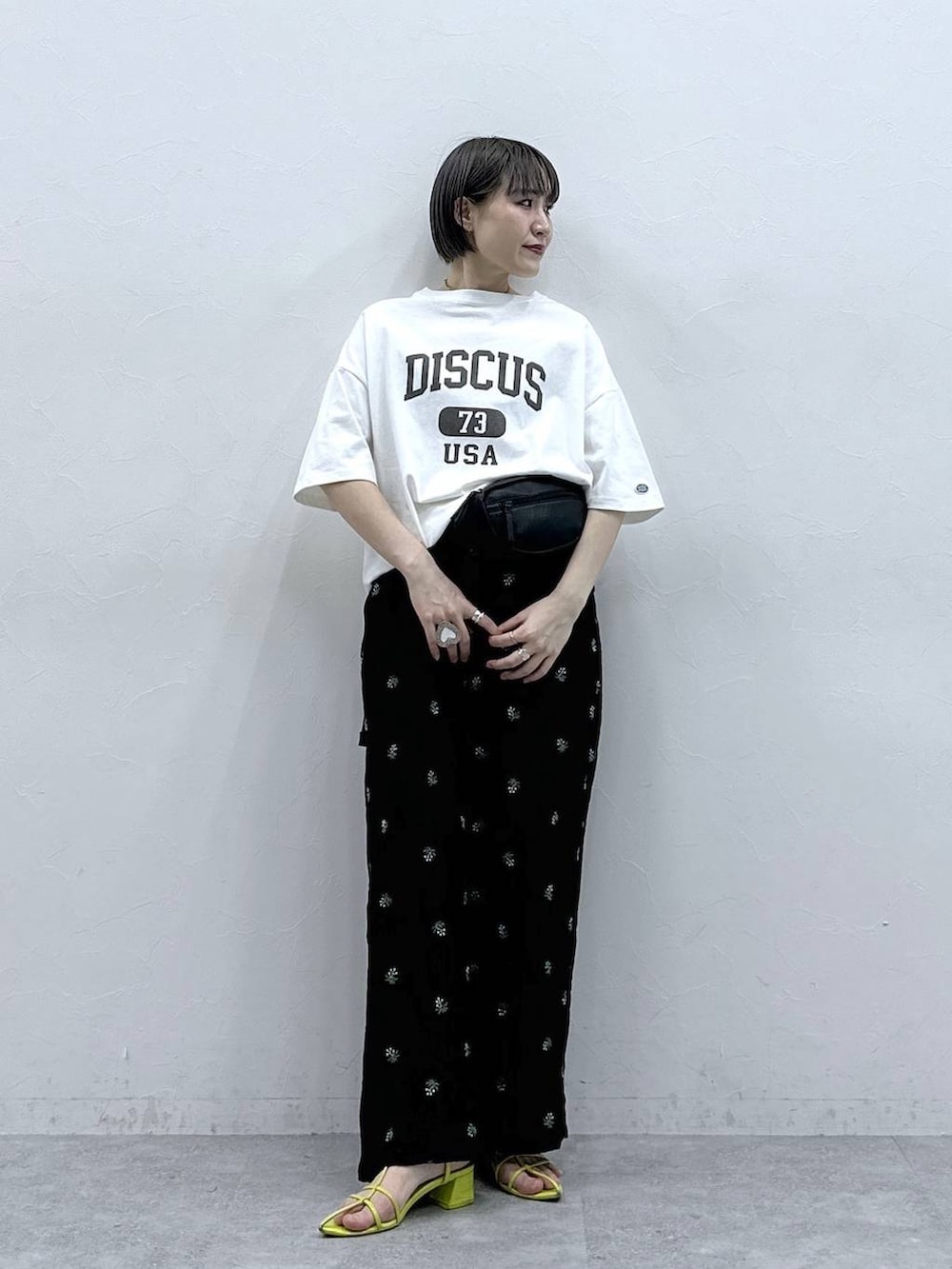 ホワイト系のTシャツ/カットソー、ブラック系のボディバッグ/ウエストポーチ、ブラック系のスラックスを着用したレディースの春コーディネートの2枚目の写真