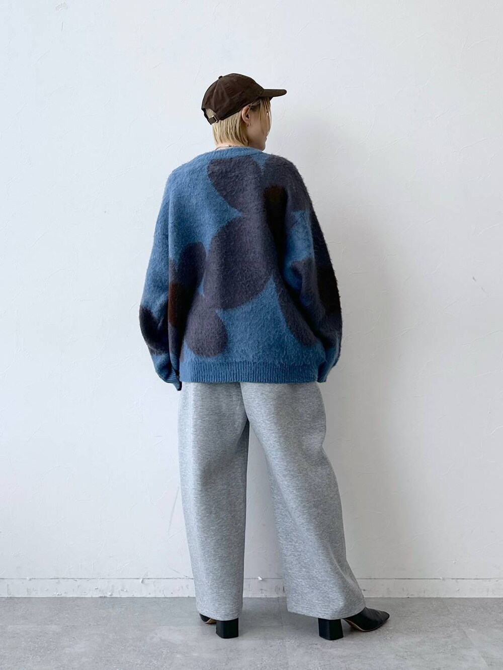 ブルー系のニット/セーター、グレー系のスウェットパンツ、ブラウン系のキャップを着用したレディースの秋コーディネートの5枚目の写真