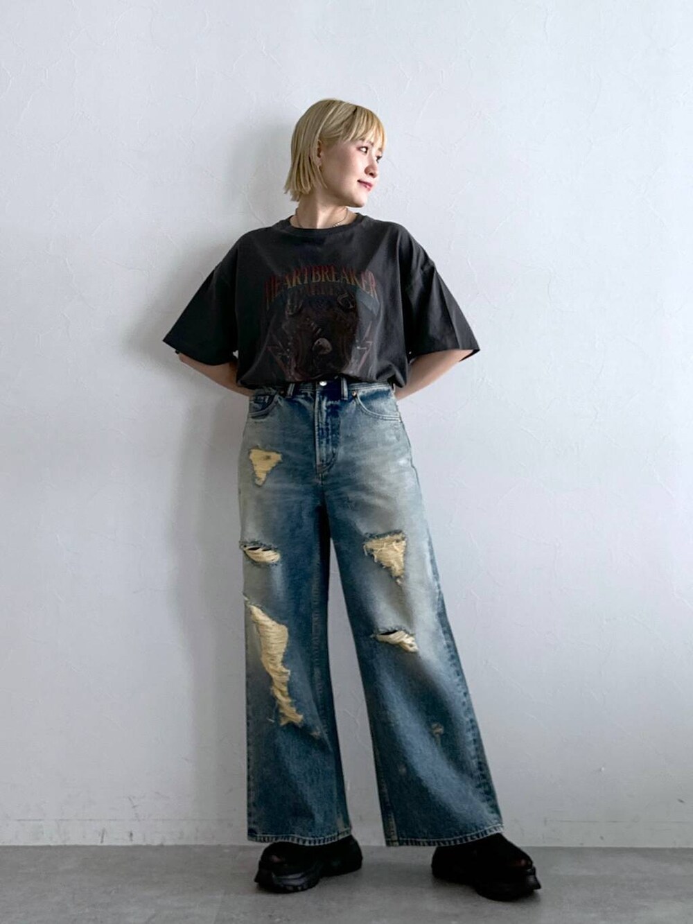 ブラック系のTシャツ/カットソー、ブラック系のサンダル、ブラック系のデニムパンツを着用したレディースの夏コーディネートの2枚目の写真