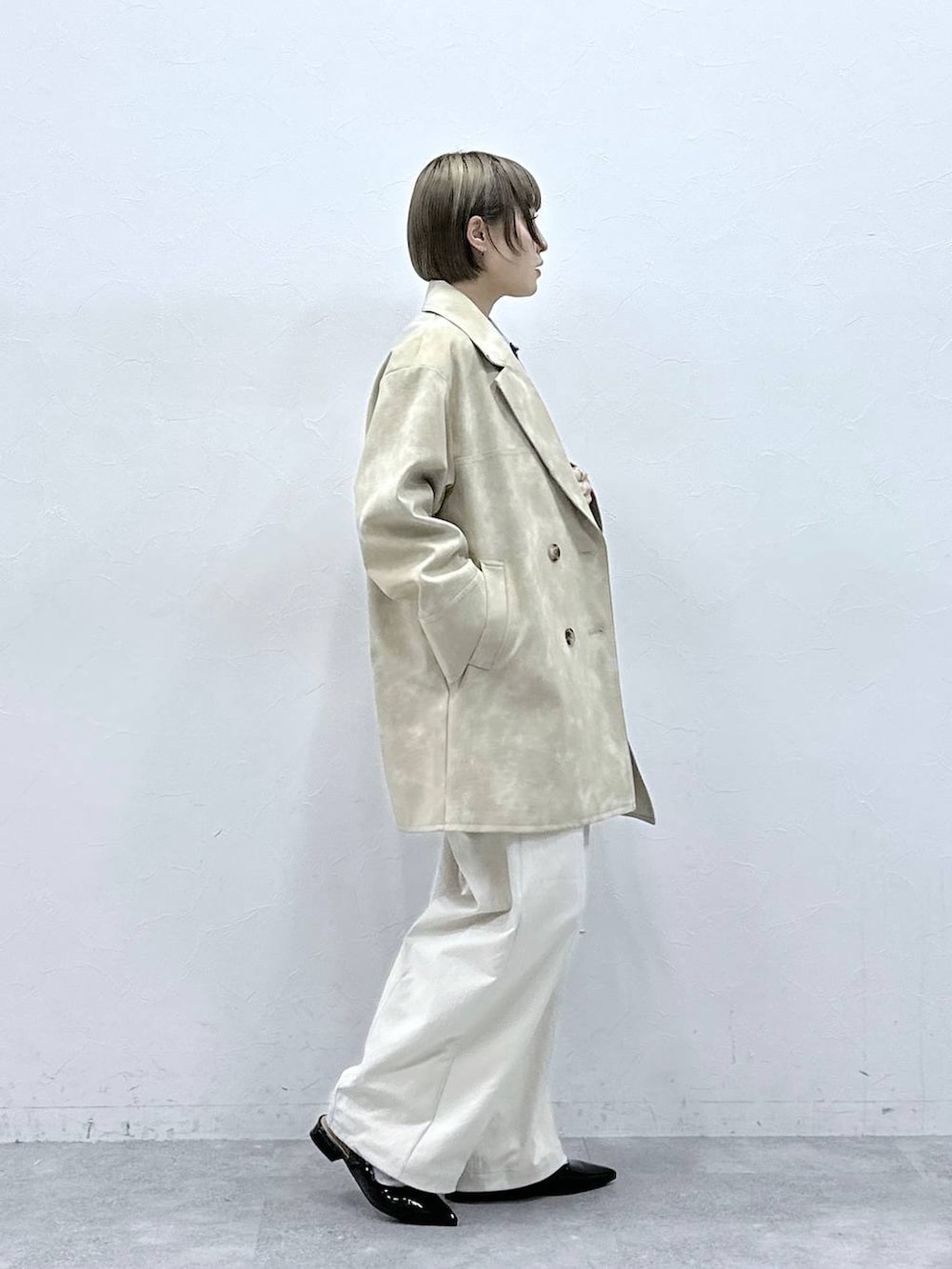 ホワイト系のチノパンツ、ブラック系のパンプス、ブルー系のカーディガン/ボレロを着用したレディースの冬コーディネートの4枚目の写真