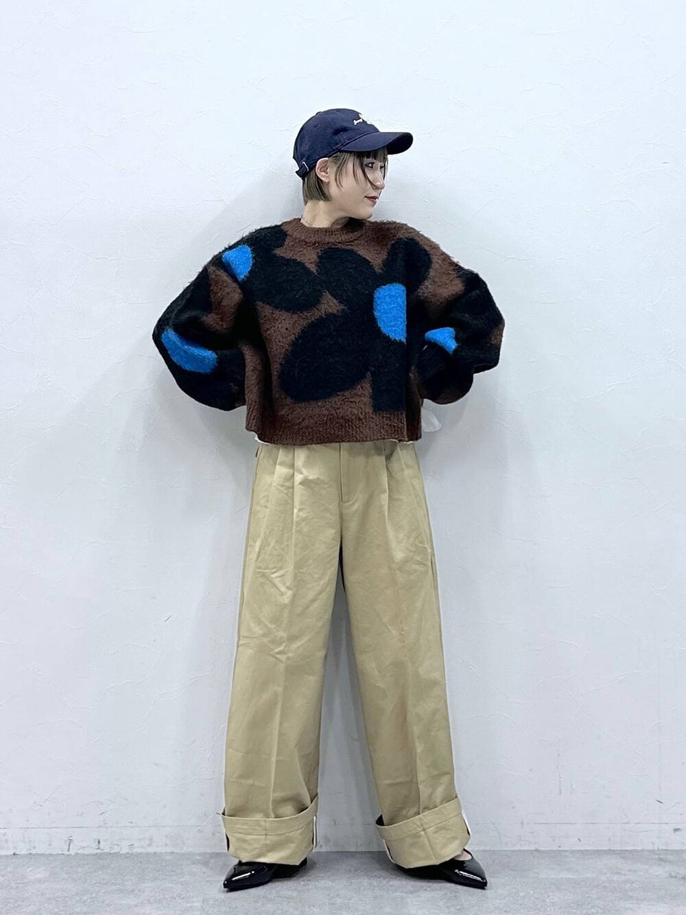 ブラウン系のニット/セーター、ブラック系のパンプス、ベージュ系のチノパンツを着用したレディースの冬コーディネートの3枚目の写真