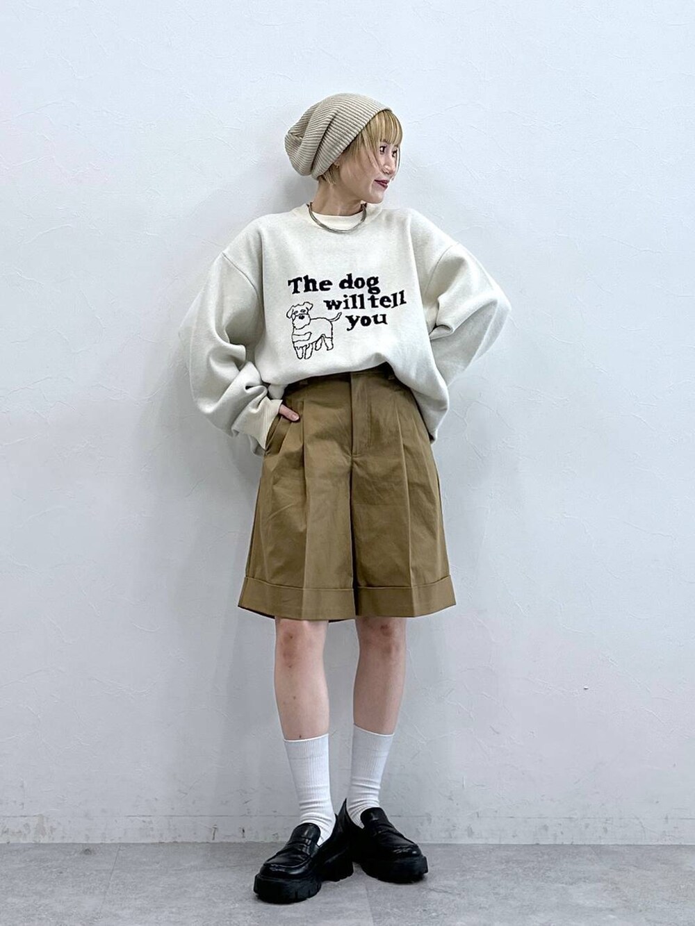 ホワイト系のニット/セーター、ブラック系のローファー、ブラウン系のチノパンツを着用したレディースの秋コーディネートの3枚目の写真