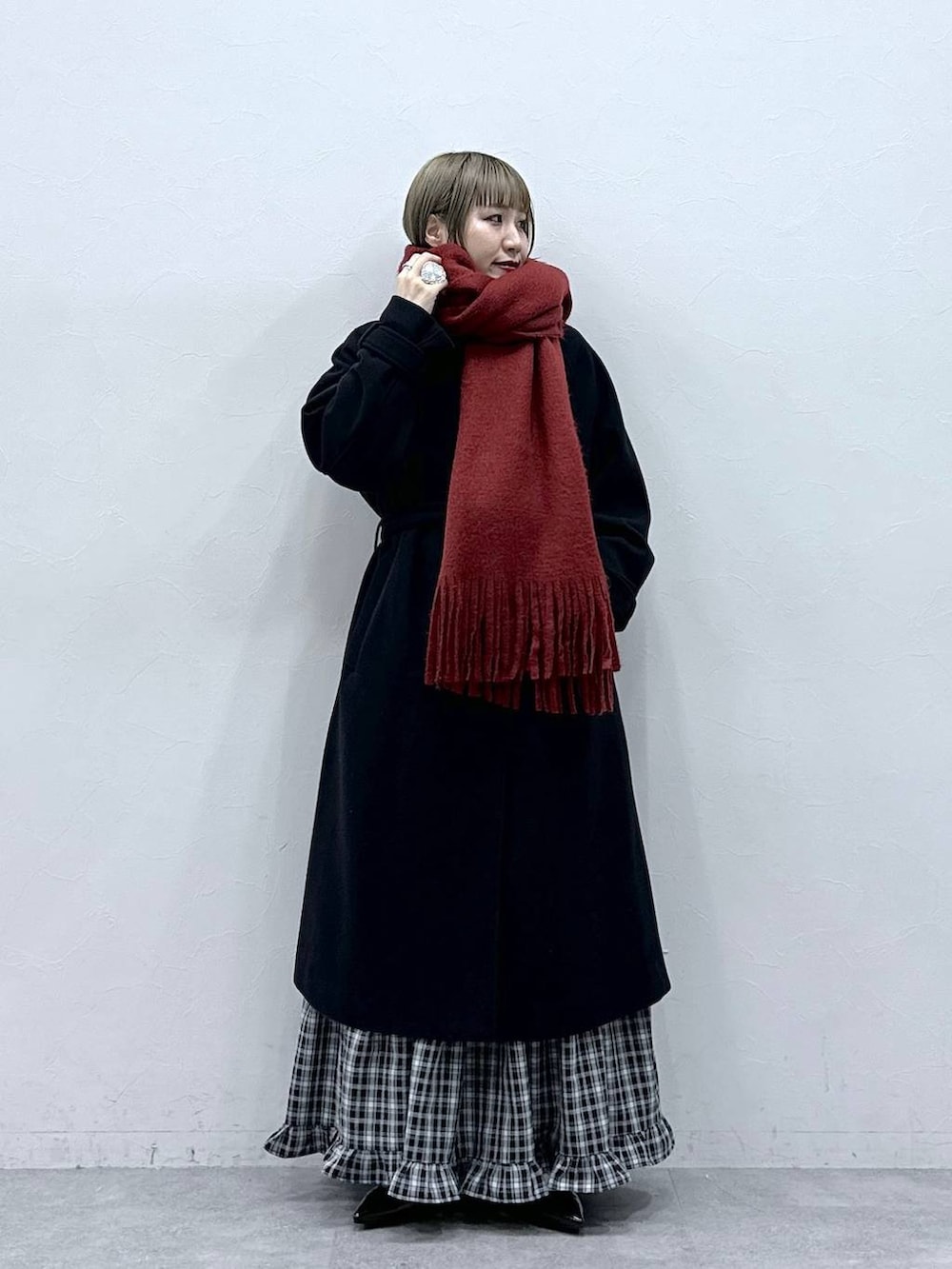 ブラック系のステンカラーコート、ブラック系のスカート、ブラック系のパンプスを着用したレディースの冬コーディネートの3枚目の写真