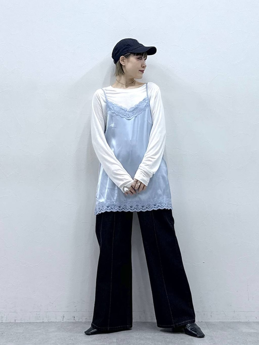 ブラック系のデニムパンツ、ブルー系のキャミソール、ホワイト系のTシャツ/カットソーを着用したレディースの冬コーディネートの4枚目の写真