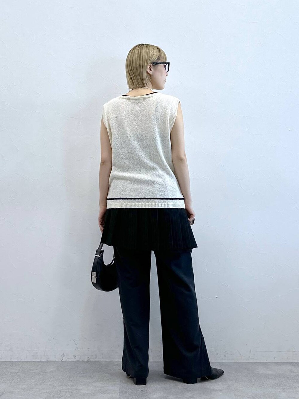 ホワイト系のニット/セーター、その他のスラックス、ブラック系のスカートを着用したレディースの夏コーディネートの7枚目の写真