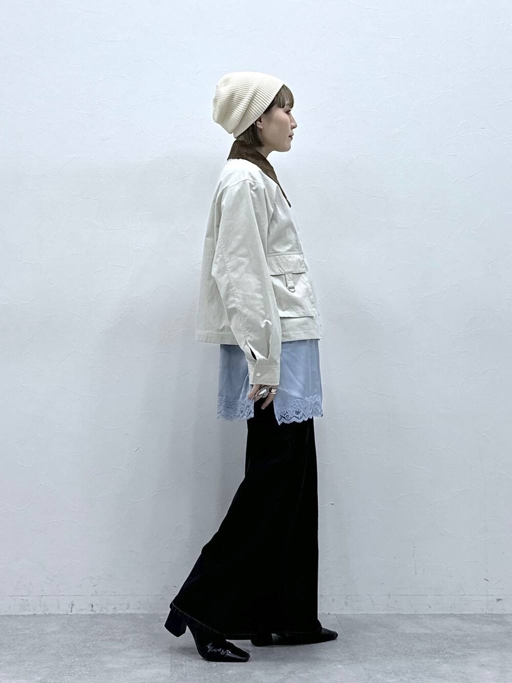 ブラック系のデニムパンツ、ホワイト系のブルゾン、ブルー系のキャミソールを着用したレディースの冬コーディネートの5枚目の写真