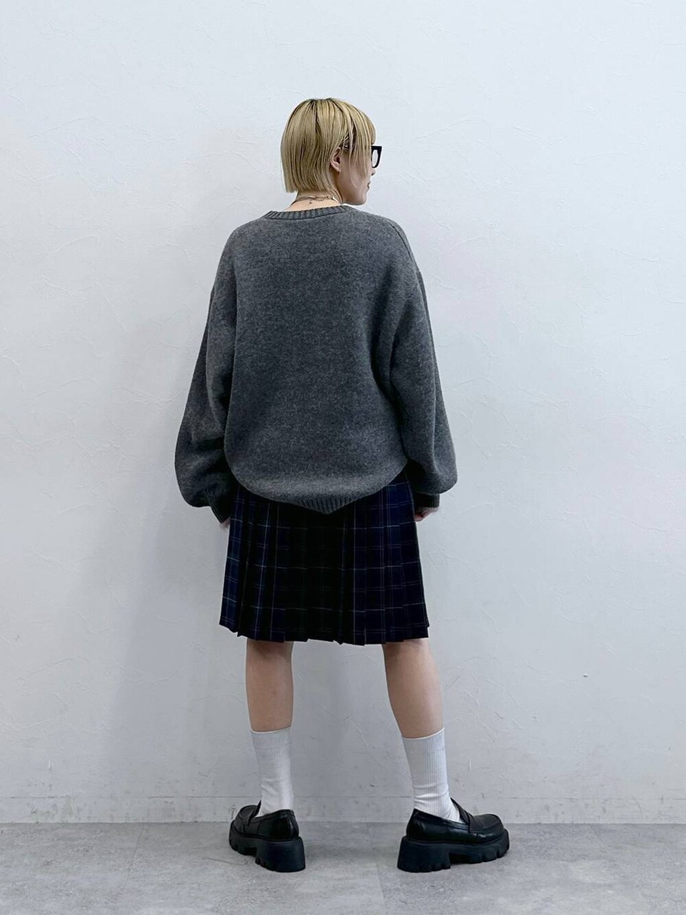 ブラック系のローファー、グレー系のニット/セーター、グリーン系のスカートを着用したレディースの秋コーディネートの6枚目の写真