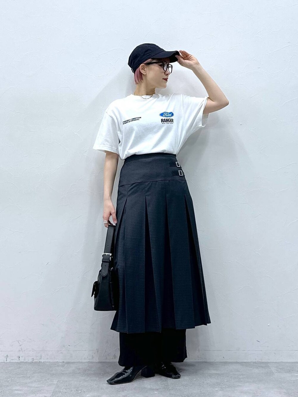 ブラック系のスラックス、グレー系のスカート、ホワイト系のTシャツ/カットソーを着用したレディースの春コーディネートの4枚目の写真