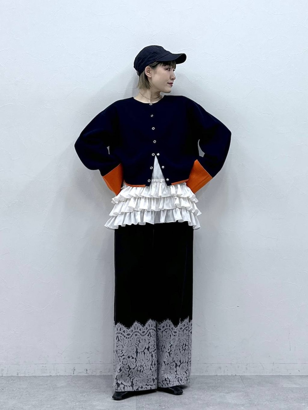 ホワイト系のキャミソール、ブルー系のカーディガン/ボレロ、ブラック系のデニムパンツを着用したレディースの冬コーディネートの2枚目の写真