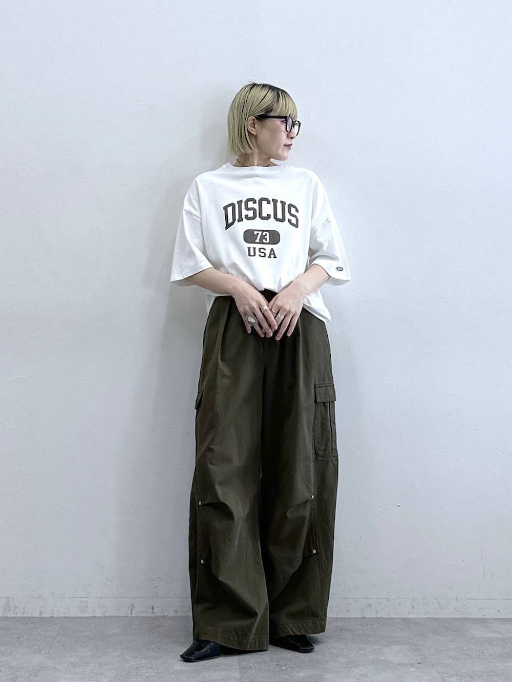 グリーン系のカーゴパンツ、ホワイト系のTシャツ/カットソーを着用したレディースの夏コーディネートの4枚目の写真