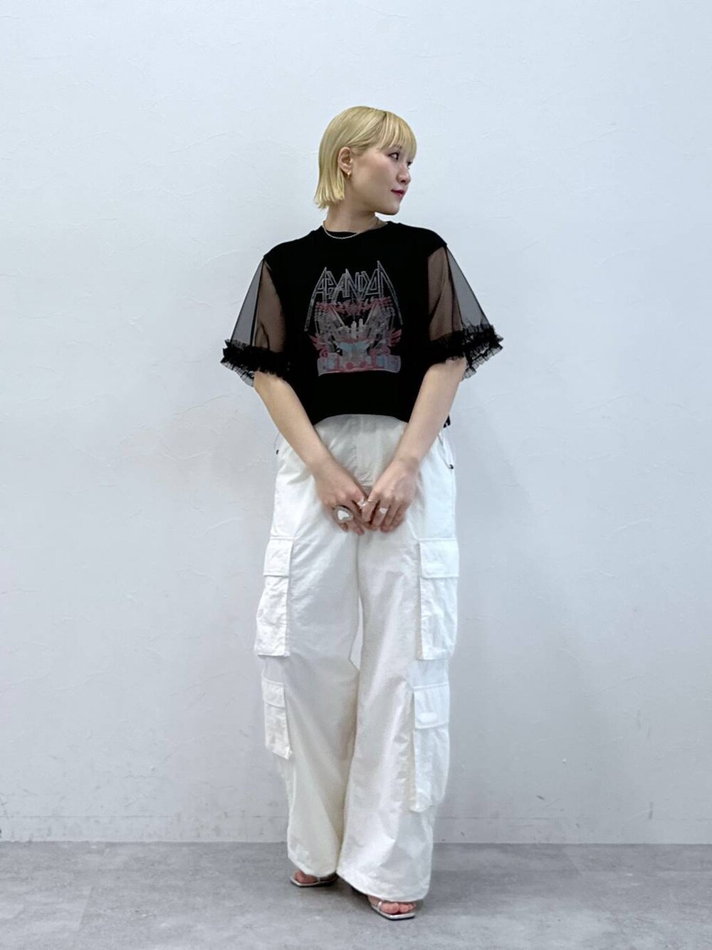 シルバー系のサンダル、ホワイト系のカーゴパンツ、ブラック系のTシャツ/カットソーを着用したレディースの夏コーディネートの2枚目の写真