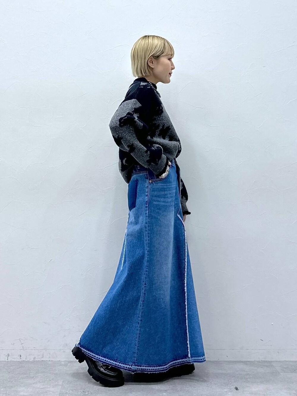 ブルー系のデニムスカート、ブラック系のニット/セーター、ブラック系のローファーを着用したレディースの冬コーディネートの4枚目の写真