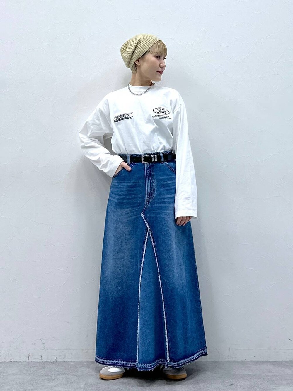 ブルー系のデニムスカート、ホワイト系のTシャツ/カットソー、ベージュ系のハンチング/ベレー帽を着用したレディースの冬コーディネートの2枚目の写真