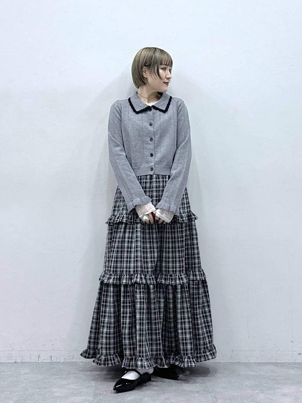 ホワイト系のTシャツ/カットソー、ブラック系のパンプス、グレー系のカーディガン/ボレロを着用したレディースの冬コーディネートの3枚目の写真