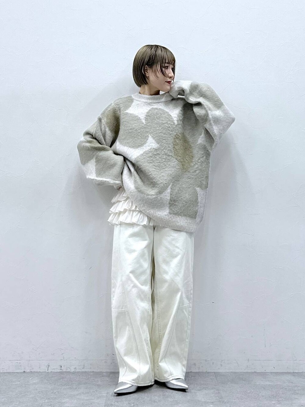 ホワイト系のニット/セーター、ホワイト系のキャミソール、ホワイト系のチノパンツを着用したレディースの冬コーディネートの3枚目の写真