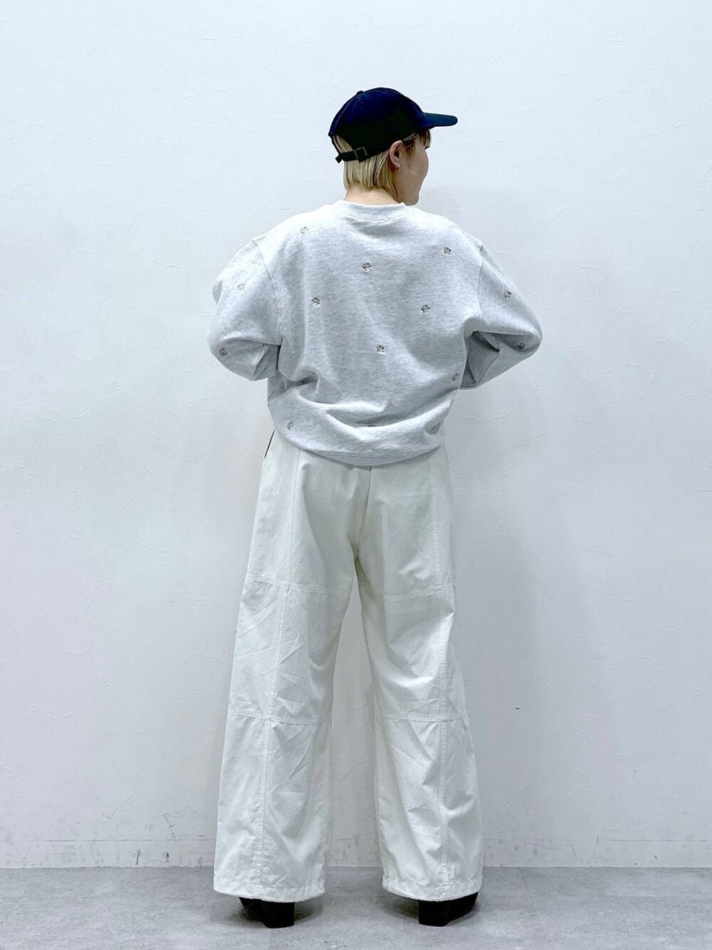 ホワイト系のカーゴパンツ、ホワイト系のスウェット、ブラック系のキャップを着用したレディースの冬コーディネートの5枚目の写真