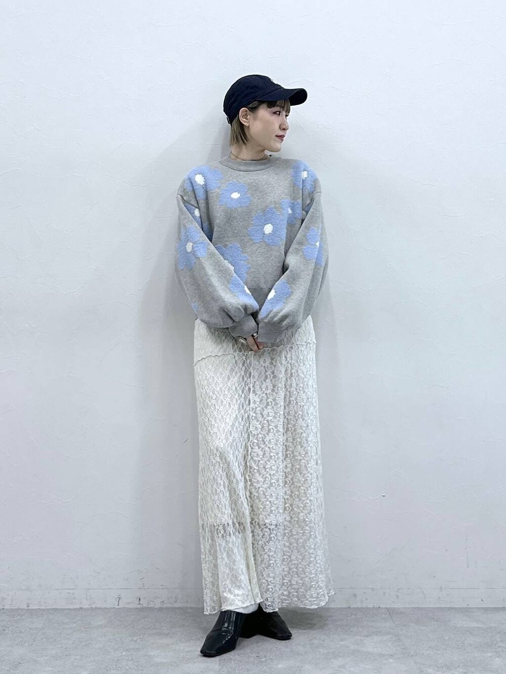 グレー系のニット/セーター、ホワイト系のスカートを着用したレディースの冬コーディネートの4枚目の写真