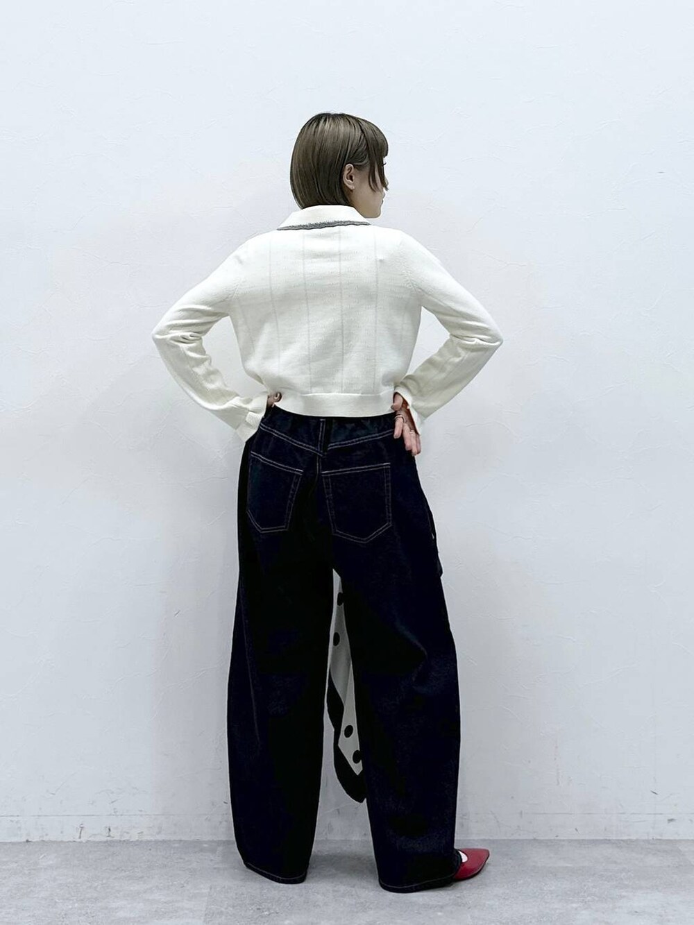 レッド系のパンプス、ホワイト系のカーディガン/ボレロ、ブラック系のデニムパンツを着用したレディースの冬コーディネートの5枚目の写真