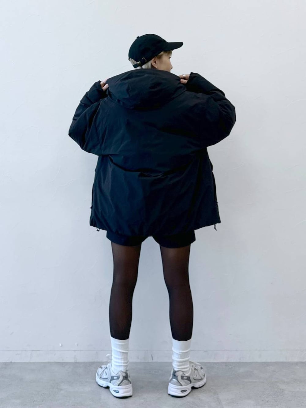 ブラック系のダウンジャケット/コート、ブラック系のその他パンツ、ピンク系のTシャツ/カットソーを着用したレディースの冬コーディネートの4枚目の写真